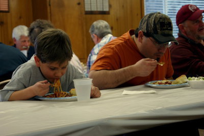 Image: Two generations slurp up their spaghetti noodles.