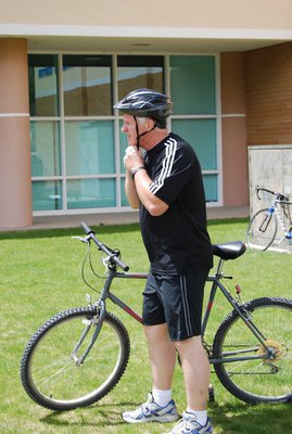 Image: Swensen bikes — Principal Swensen gets ready to jump on his bike after the swim.