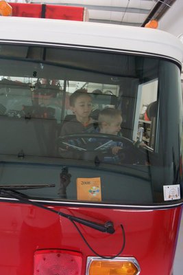 Image: Can I drive? — Isaac Clark (9-years-old) has his little brother, Jack, on his lap trying to drive the big engine. The truck may not be moving, but Jack imagination must surely be taking him somewhere.