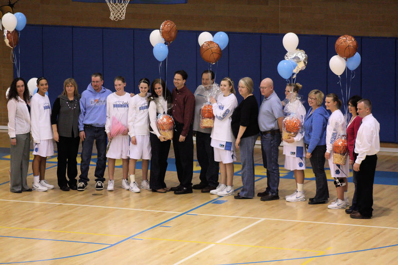 Image: Seniors and Parents — The senior players and their parents are honored before the game. The graduating seniors are Dianne Washington, Taylor Rock, Jenessa Crafts, Aubry Boehme, Amy Andrus and Nicole Hansen.
