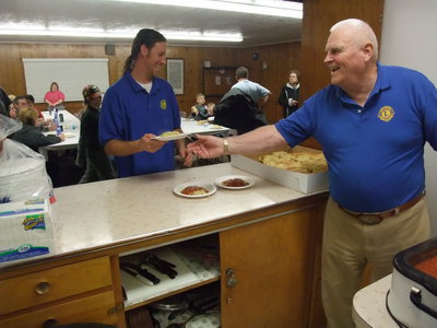 Image: Hansen serves — No sauce for this one as Keith Hansen hands Matthew Downs a plate for noodles only.